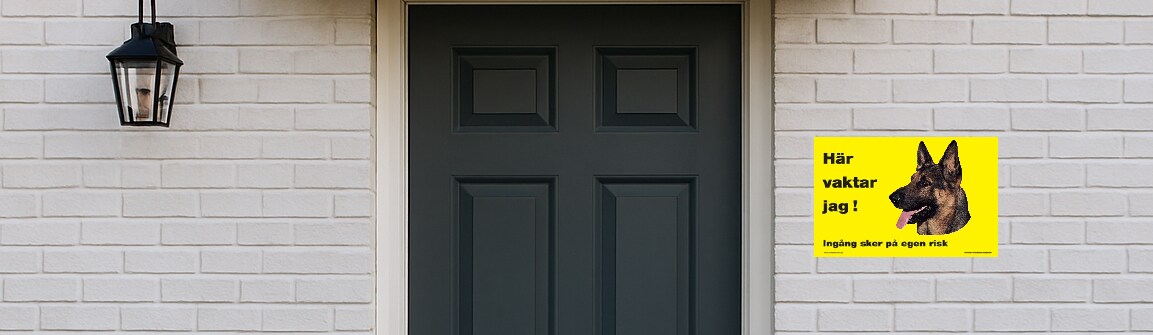 Ytterdörr med gul skylt och en schäfer på